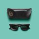 A pair of sunglasses and case on a blue background