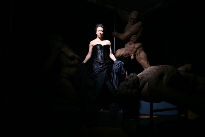 A woman in black dress sitting on top of a chair.