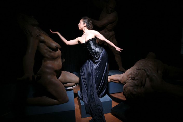 A woman in black dress standing on top of a platform.