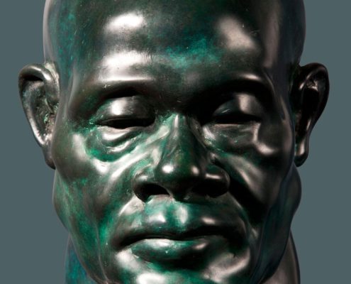 A bronze bust of a man with no hair.