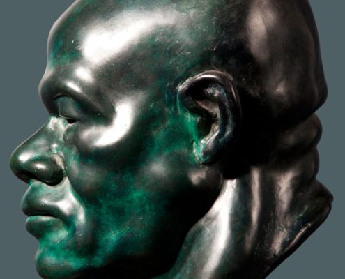 A green statue of a man 's head with no face.