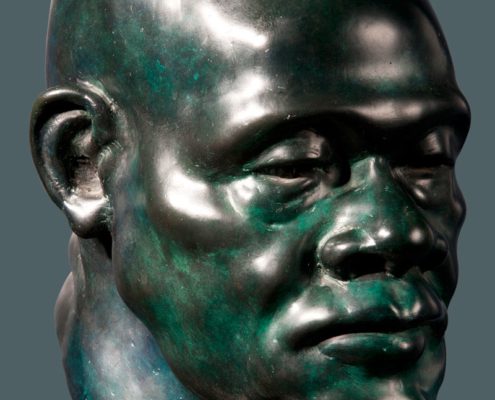 A bronze head statue of a man with a beard.