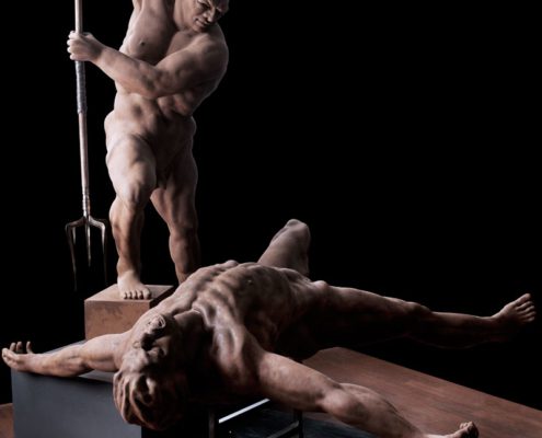 A statue of two men laying on top of a table.