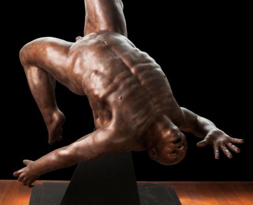 A statue of a man doing a handstand.