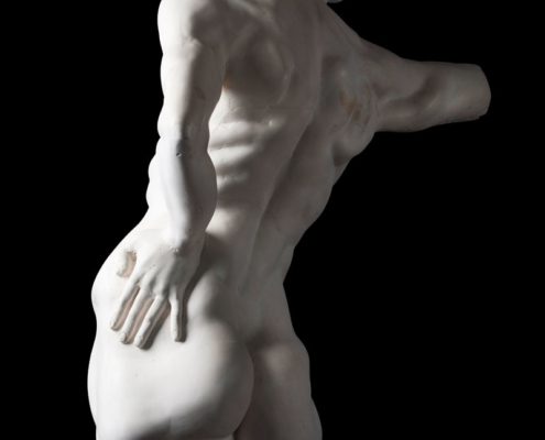 A white statue of a man with his back turned.