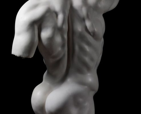 A white statue of a man with no shirt.