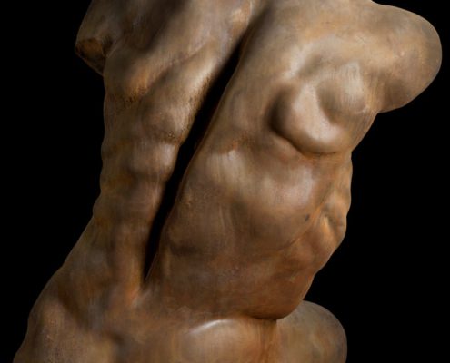 A sculpture of a naked man with no shirt.