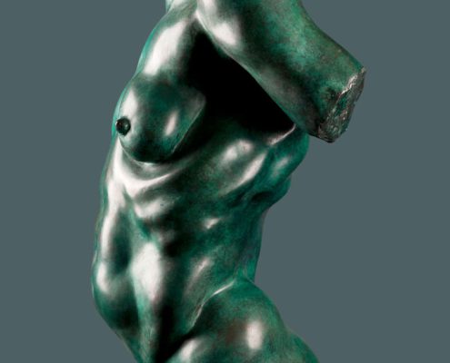 A green statue of a man with no shirt.