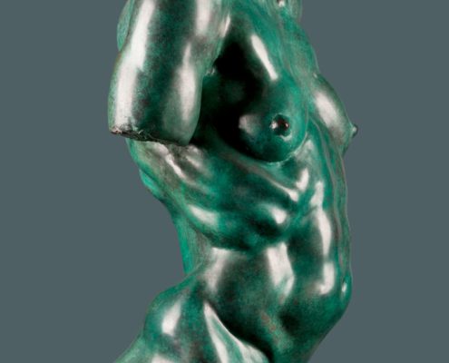 A green statue of a man with no shirt.