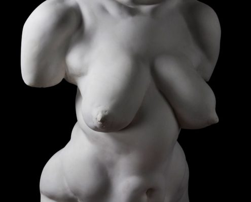 A white statue of a woman with her hands on the chest.