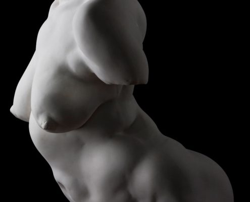 A white statue of a naked woman with no shirt.