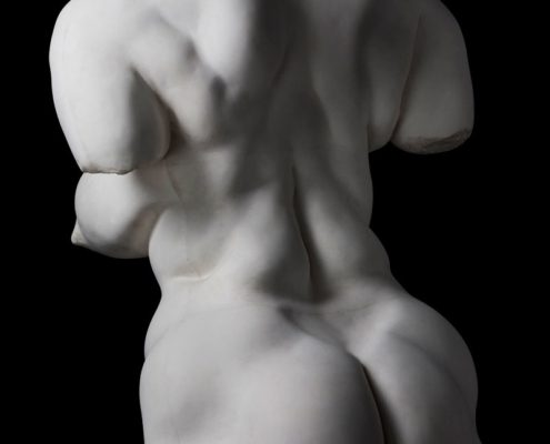 A white statue of a man with no shirt.