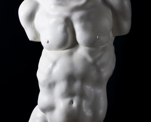 A white statue of a man with no shirt.