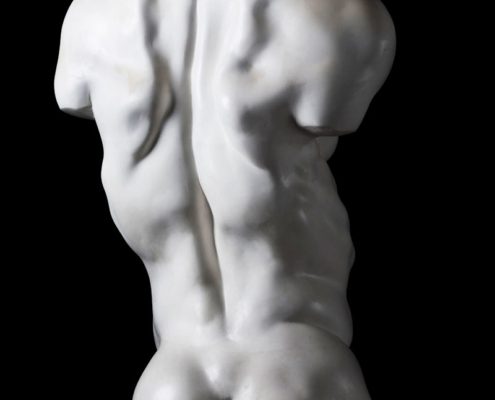 A white statue of a man with no shirt.