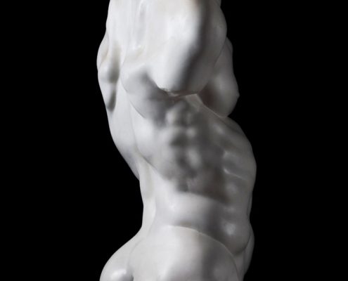 A white statue of a man with no shirt.