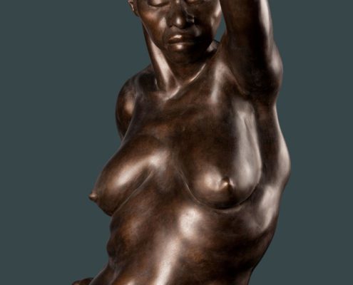 A bronze statue of a woman with her arm raised.