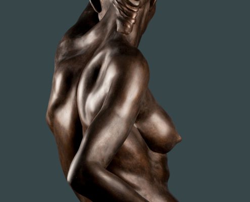 A bronze statue of a woman with her arms crossed.