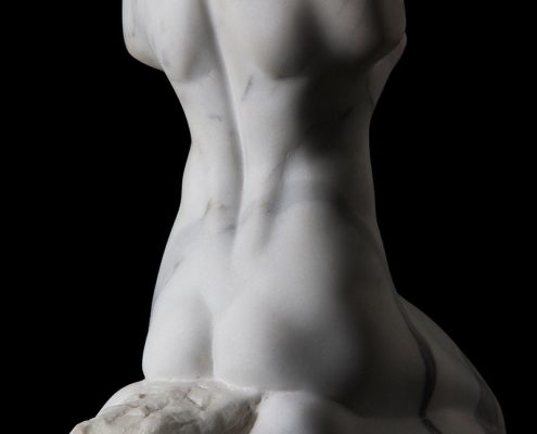 A white statue of a woman with her back turned.