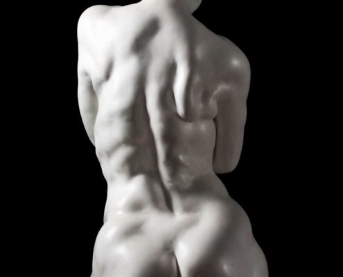 A white statue of a naked man with no shirt.