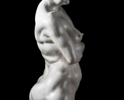 A white statue of a woman with her arms crossed.