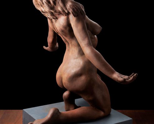 A naked woman sitting on top of a box.