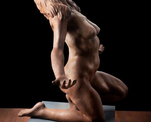 A sculpture of two people sitting on top of each other.