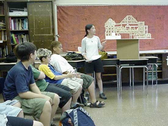 A woman standing in front of a group of people.