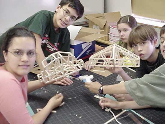 A group of young people holding wooden models.