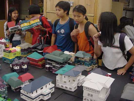 A group of kids standing around a table with boxes.