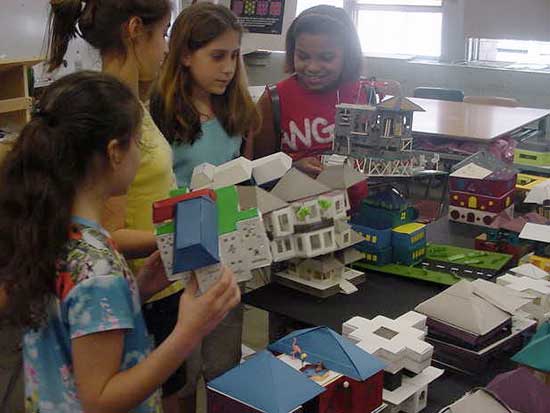 A group of girls standing around some paper