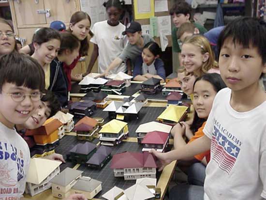 A group of children sitting around a table with books.