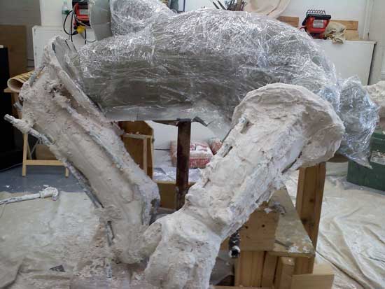 A large white dinosaur skeleton in the process of being made.