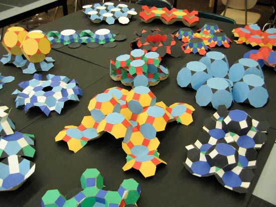 A table with many different colored paper shapes.