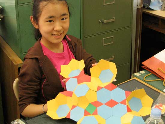 A girl holding onto some paper and smiling