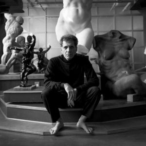 A man sitting on steps in front of statues.