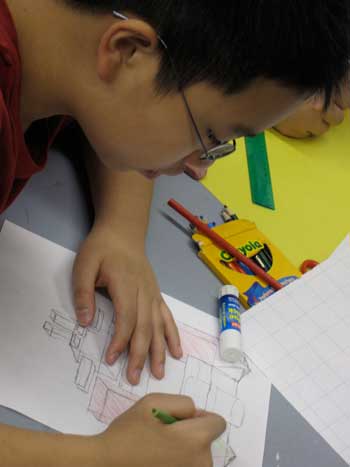 A boy is drawing on paper with markers.