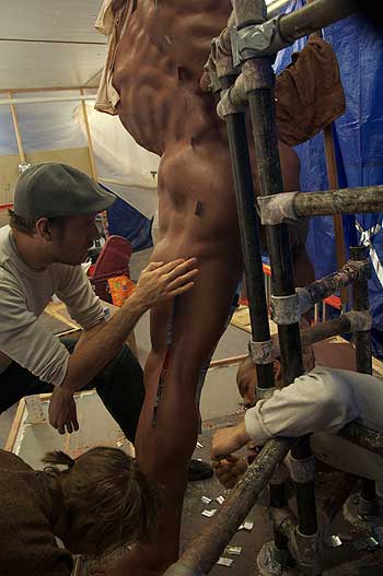 A man is standing up and getting his body worked on.