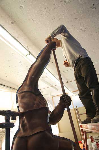 Two men are doing a handstand on the floor.