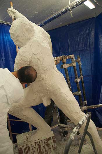 A man in white suit and goggles working on something.