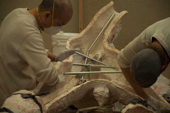 A man in white shirt and gloves working on something.