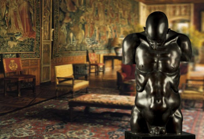 A statue of a man in a room with furniture.